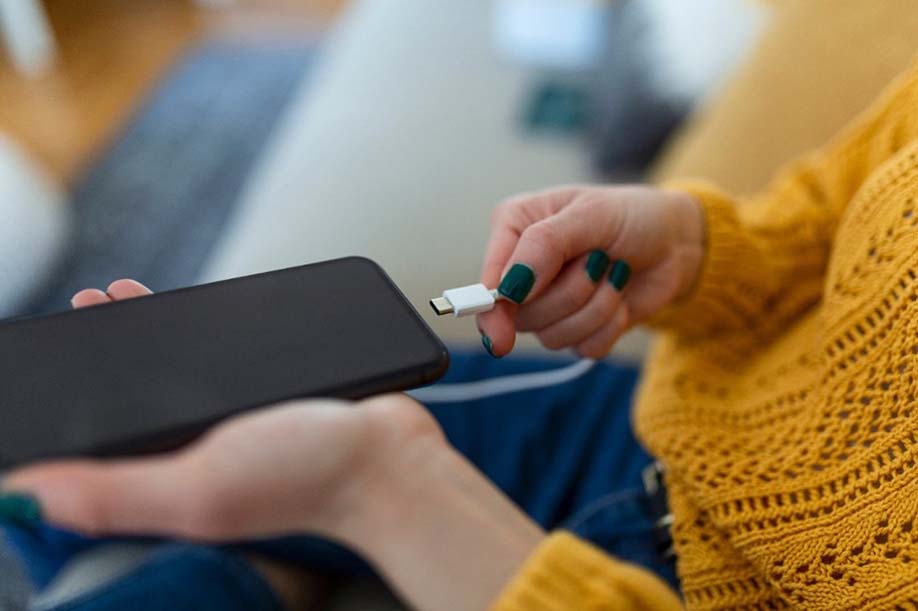 person plugging phone into charge